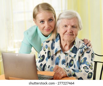 Senior Woman With Her Caregiver In Home Using Laptop. MANY OTHER PHOTOS FROM THIS SERIES IN MY PORTFOLIO.