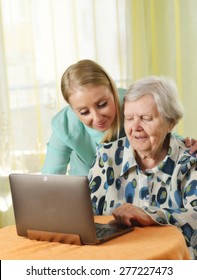 Senior Woman With Her Caregiver In Home Using Laptop. MANY OTHER PHOTOS FROM THIS SERIES IN MY PORTFOLIO.