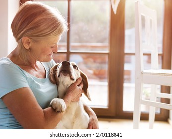 Senior Woman With Her Dog Inside Of Her House.