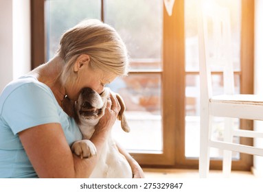 Senior Woman With Her Dog Inside Of Her House.