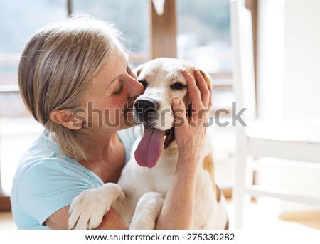 Senior woman with her dog inside of her house.