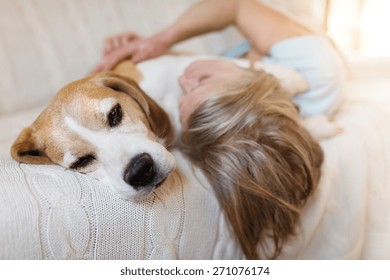 Senior Woman With Her Dog On A Couch Inside Of Her House.