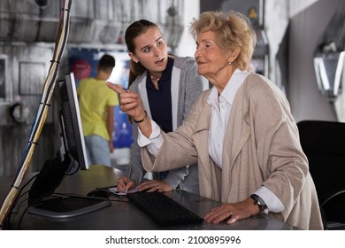 Senior Woman And Her Granddaughter Using Computer To Solve Riddle In Escape Room.