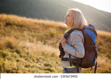 Senior Woman Is Hiking In Mountain. Active Retirement. 