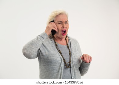 Senior Woman Holding Cell Phone. Old Lady On White Background. I Can't Hear You.