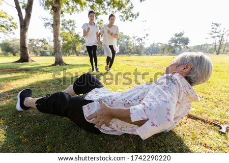 Senior woman is holding her hip,severe pain in her muscle,broken bone,injury to the waist,old elderly lying on the ground,she fell down while strolling,daughter,granddaughter ran to help grandmother