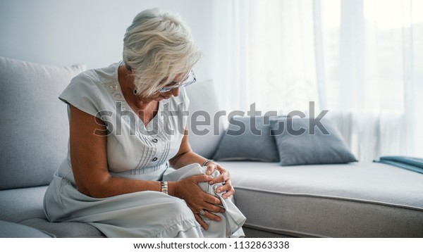 Senior
woman holding the knee with pain. Old age, health problem and
people concept - senior woman suffering from pain in leg at home.
Elderly woman suffering from pain in knee at
home