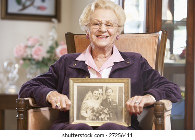 Senior Woman Holding An Old Wedding Photo