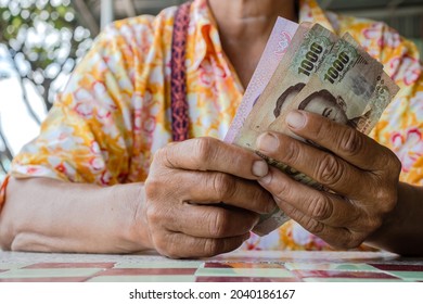 senior woman are holding thai baht banknotes money, banknote money in elderly people hand, savings money and financial business concept - Shutterstock ID 2040186167