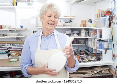 Senior Woman Holding Vase In Pottery Studio