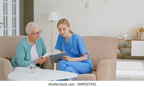 Senior woman holds bottle of pills listening to doctor advice at appointment in light office