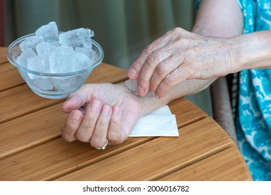 Senior Woman Holds Ice Cube On Her Wrist. How To Stay Cool In Hot Weather. Beat The Heat. No Face, Only Hands. Close Up.