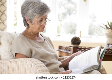 Senior Woman At Home Reading Book