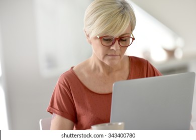 Senior Woman At Home Using Laptop Computer