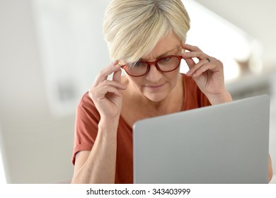 Senior woman at home using laptop computer