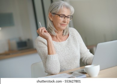 Senior Woman At Home Websurfing On Laptop Computer