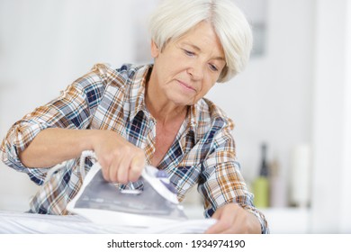 A Senior Woman Ironing Clothes