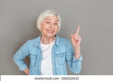 Senior Woman In Jeans Jacket Studio Isolated On Grey Wall Creative Idea