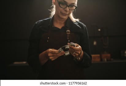 Senior Woman Jeweler With Professional Ring Finger Measurer In Workshop. Female Jewelry Maker With Ring Gauge In Workshop.