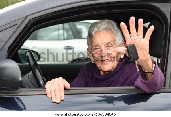 senior woman with keys of the\
car