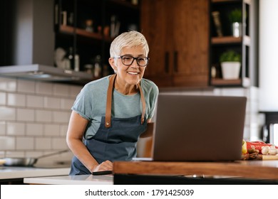 Senior Woman Looking For Cooking Recipes Online On Her Laptop