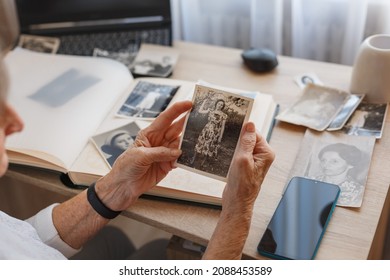 Senior Woman Is Looking Her Own Old Photos At Home. Elderly Woman Has Got Smile While Remembering How Young And Beatiful She Was. Selective Focus. Photo Was Taken In 1953