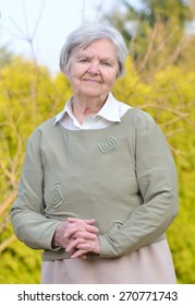 Senior Woman Looking And Smiling In Garden On Blue Sky. MANY OTHER PHOTOS FROM THIS SERIES IN MY PORTFOLIO. 