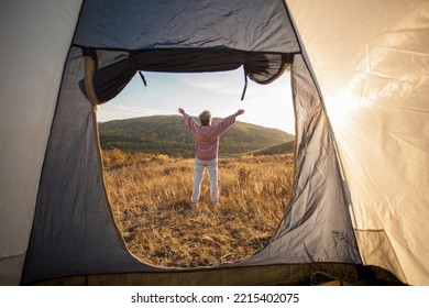 Senior Woman Looks Into The Distance With His Hands Up Near The Tent At The Mountain, Autumn Fall Season