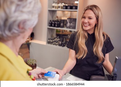 Senior Woman Making Contactless Payment To Stylist In Salon With Credit Card - Powered by Shutterstock