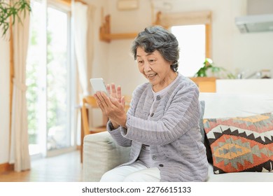 Senior woman making a videophone call with her grandchildren at home - Powered by Shutterstock