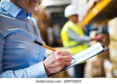 Senior woman manager and man worker working in a warehouse. - Powered by Shutterstock