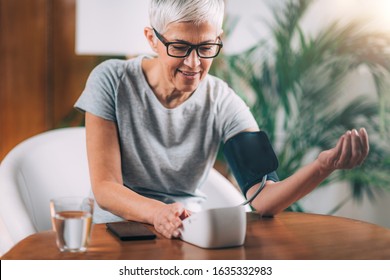 Senior Woman Measuring Blood Pressure At Home