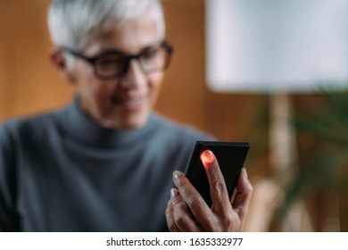 Senior Woman Measuring Pulse Or Heart Rate With Smart Phone