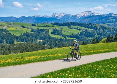 senior woman mountain biking on a electric mountainbike in early spring, in the Allgaeu Area, beolow Hochgrat summit near Oberstaufen,bavarian alps,Germany - Powered by Shutterstock