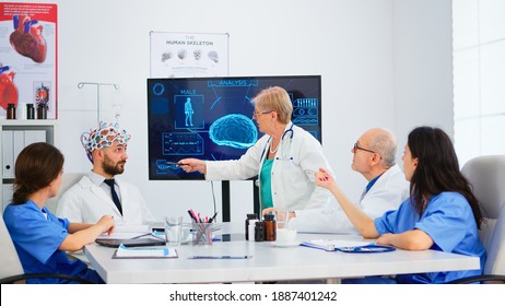 Senior Woman Neurologist Analysing Brain Functions Using High Tech In Medical Conference Room, Doctor Testing New Innovation. Medic Studying Diagnosis For Treatment Of Patients Working In Boardroom