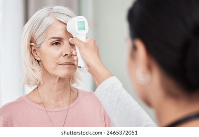 Senior, woman and nurse for forehead temperature, digital thermometer and health and medical appointment. Measure, fever and wellness clinic with professional in serious examination and equipment - Powered by Shutterstock