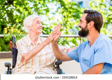 Senior woman and nurse giving High five in nursery home