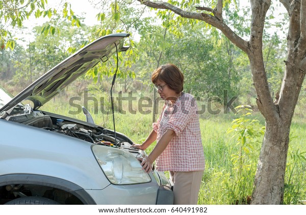 senior woman with old\
car, broken car.
