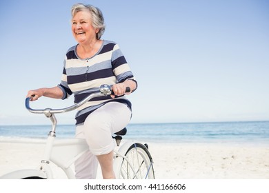 Senior Woman On A Bike On The Beach