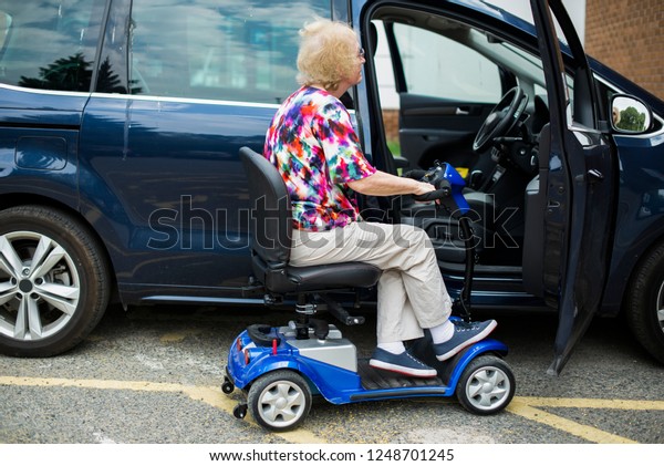 Senior woman on an\
electric wheelchair