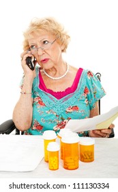 Senior Woman On The Phone Discussing Her Medical Bills With The Health Insurance Company.  White Background.