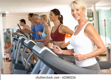 Senior Woman On Running Machine In Gym