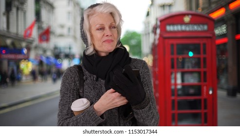 Senior Woman On Vacation In London Waiting For Rideshare With Cell Phone