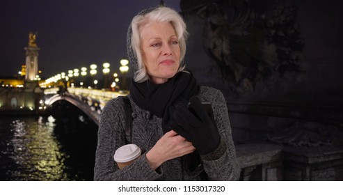 Senior Woman On Vacation In Paris Waiting For Rideshare Smartphone