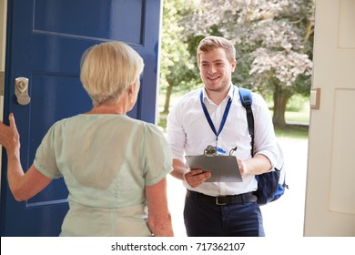 Senior Woman Opens Door To Male Charity Worker Doing Survey