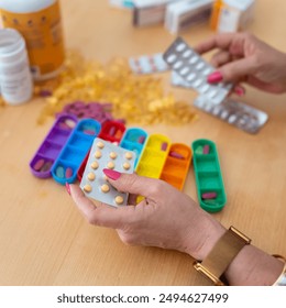 A senior woman organizing the pills she must take during the week and putting them in colored pillboxes. - Powered by Shutterstock