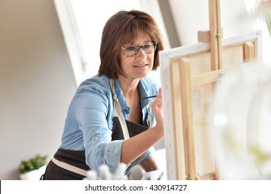 Senior Woman Painting On Canvas