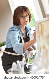 Senior Woman Painting On Canvas