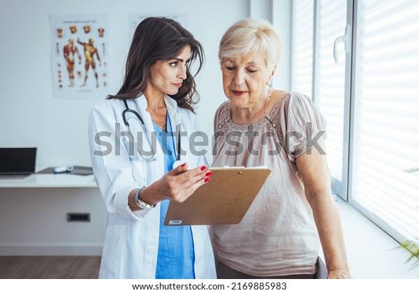 Senior\
woman patient talking with female doctor during a medical\
consultation at the hospital office. Doctor offering medcine for a\
patient. Smiling patient in the doctor\'s\
office