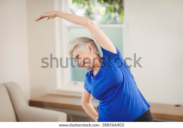 Senior Woman Performing Stretching Exercise Home ภาพสต็อก 388566403 ...